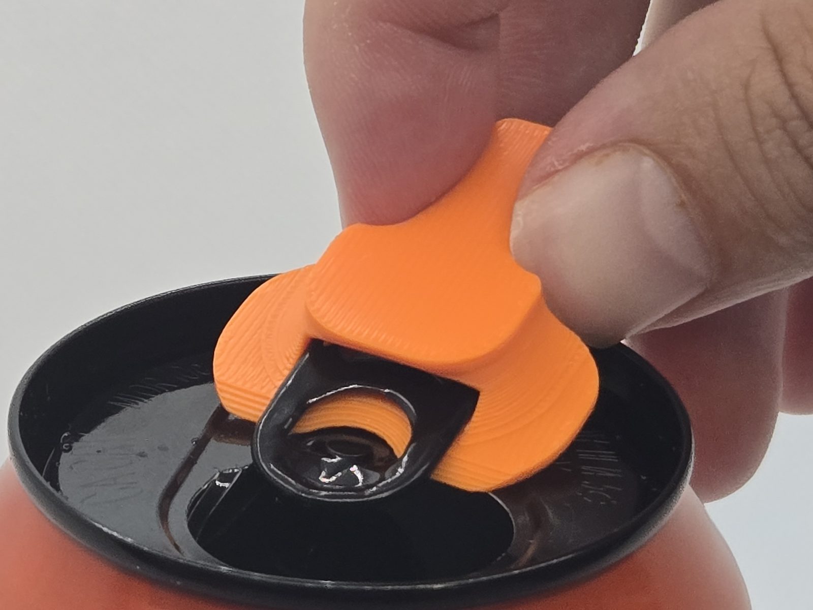 Dropping the can cover over the pull tab of a soda can - a pull tab cover that stays attached to the can
