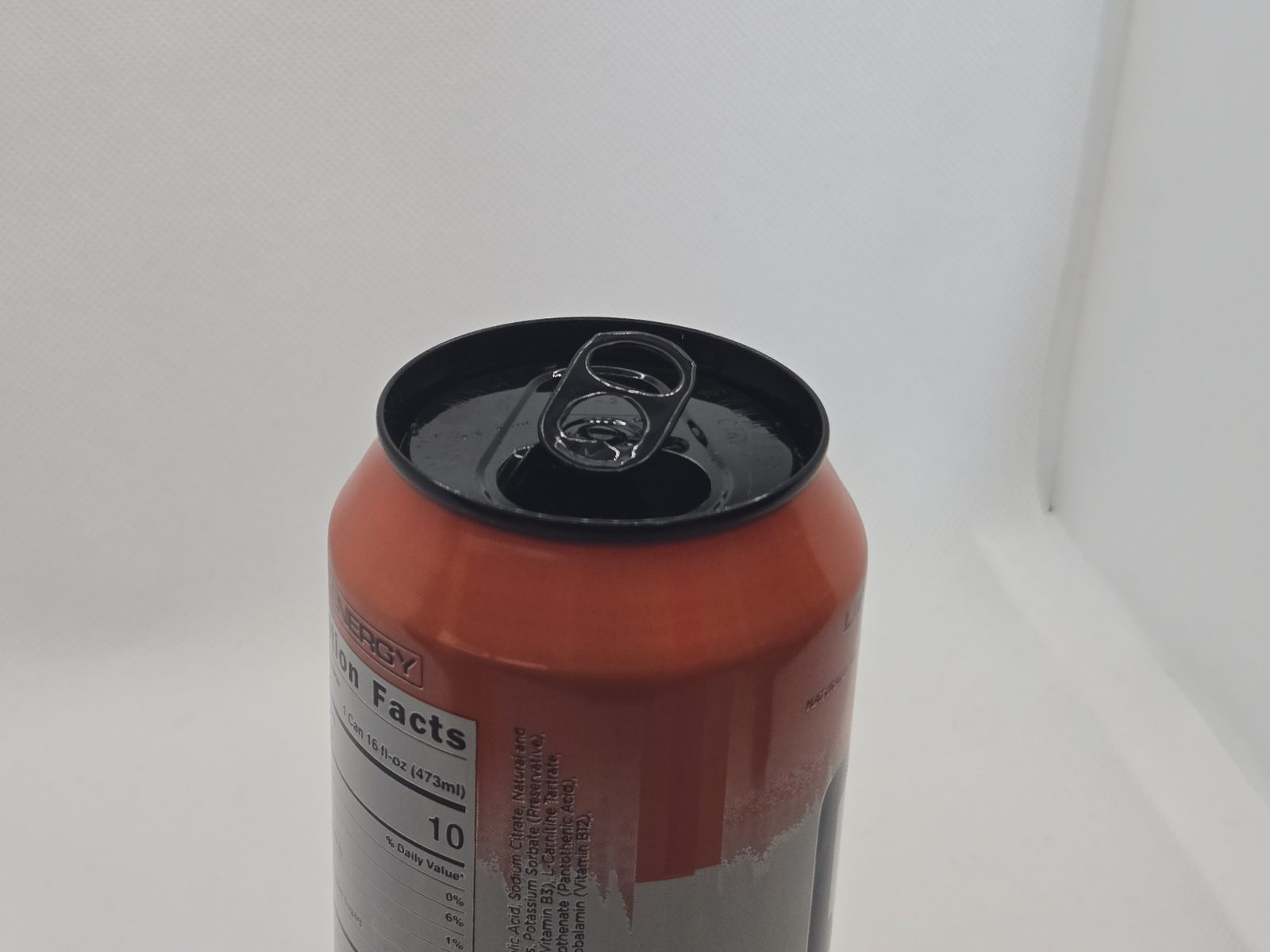 An open soda can before the can cover goes on, showing the pull tab and the opening